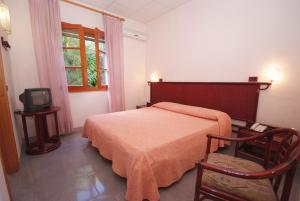 - une chambre avec un lit et une télévision dans l'établissement Residence Il Gabbiano Azzurro, à Marciana Marina