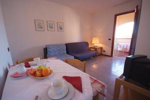 una sala de estar con una mesa con un bol de fruta. en Residence Il Gabbiano Azzurro, en Marciana Marina