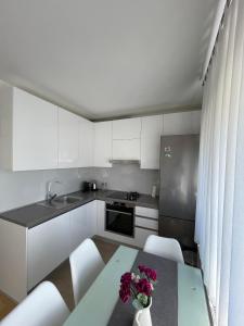 una cocina con armarios blancos y una mesa con flores. en Lucky place apartment - FREE PARKING SPOT, en Zagreb