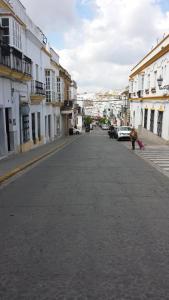 una calle vacía con una persona caminando por la calle en Hostal Cuesta de Belén, en Arcos de la Frontera