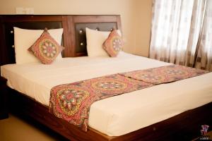 1 dormitorio con 1 cama grande con sábanas y almohadas blancas en Elepath Lodge- Pinnawala en Pinnawala