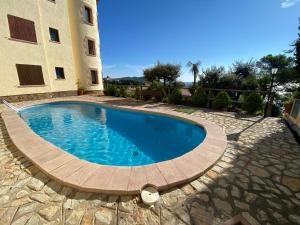 a large swimming pool in front of a building at Wonderful Apartment with Outstanding Views - Calella de Palfrugell in Calella de Palafrugell
