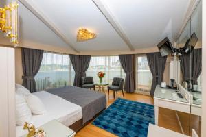 イスタンブールにあるアーデン シティ ホテル スペシャル カテゴリーのベッドと大きな窓が備わるホテルルームです。