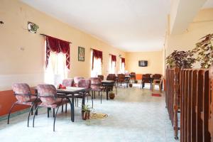 a dining room with tables and chairs and windows at Hotel TamilNadu - Yercaud in Yercaud
