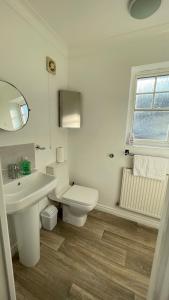 een witte badkamer met een toilet en een wastafel bij Stylish 4beds home, perfect for Company contractors and family stays - NEC, Airport, HS2, Resort World in Marston Green