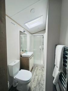 a white bathroom with a toilet and a sink at Hideaway Retreat with Hot Tub in York