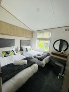 a bedroom with two beds and a mirror in it at Hideaway Retreat with Hot Tub in York