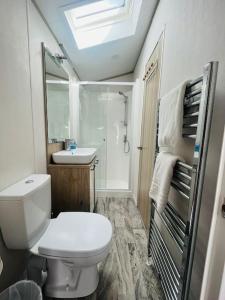 a bathroom with a white toilet and a sink at Hideaway Retreat with Hot Tub in York