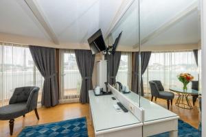 a room with a desk with a television and chairs at Arden City Hotel-Special Category in Istanbul