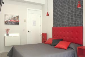 a bedroom with a bed with a red headboard at Hostal Lauria in Madrid