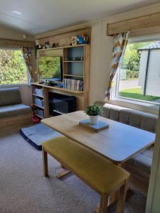 a living room with a table and a couch at 24 Chestnut Grove Caravan in Humberston