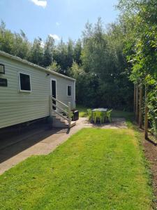 a patio with a picnic table and a trailer at 24 Chestnut Grove Caravan in Humberston
