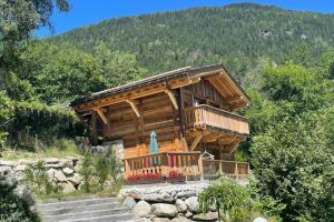drewniany domek z werandą i schodami do niego w obiekcie Chalet 3 étoiles pour 4 pers avec vue imprenable sur la vallée de Chamonix w mieście Les Houches