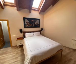 a bedroom with a large white bed with a window at Duplex Kasares en Sesué No VU HUESCA24037 in Sesué