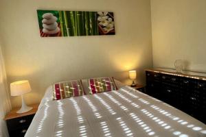 ein Schlafzimmer mit einem Bett und einem Gemälde an der Wand in der Unterkunft Une pause à Bénodet in Bénodet