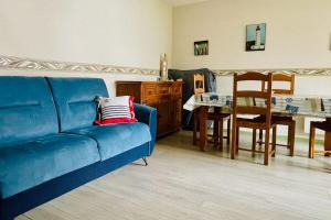 ein Wohnzimmer mit einem blauen Sofa und einem Tisch in der Unterkunft Une pause à Bénodet in Bénodet