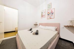 ein Schlafzimmer mit einem großen Bett mit Schuhen drauf in der Unterkunft Agostino's Apartment in Genua