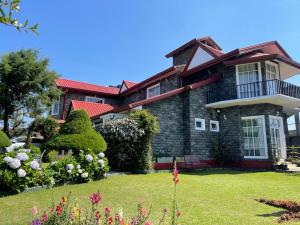 a large house with a green yard in front of it at The Rosedale Grand Bungalow Nuwara Eliya in Nuwara Eliya