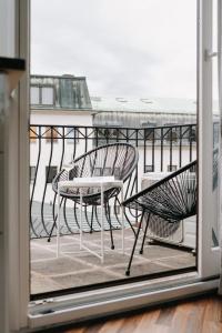uma varanda com 2 cadeiras e uma mesa em Appartement Residenz Panorama - Einzigartiges Loft im Herzen von Würzburg mit 2 Balkonen und Panorama-Aussicht! em Wurtzburgo