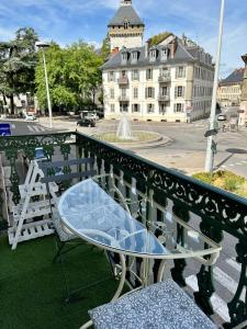 a table and chairs on a balcony with a building at Appartement d exception 100m2 avec Parking - Centre historique in Chambéry