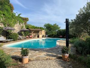 a swimming pool with a stone walkway around it at LA BOULANGERIE in Saint-Sauveur-de-Cruzières