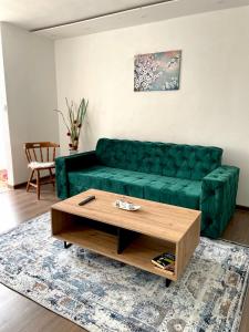 - un canapé vert dans le salon avec une table basse dans l'établissement Your home away from home, à Sarajevo