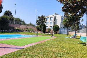 a park with a swimming pool and a building at Piso en Rías Bajas con piscina RIANXO in Rianjo