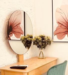 a table with a mirror and a vase with flowers at Tennessee Studio Malaga in Málaga +18 photos