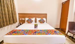 een slaapkamer met een groot bed en een kleurrijke deken bij FabHotel Radha Residency in Pondicherry