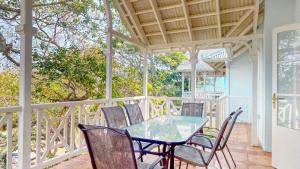 a patio with a table and chairs on a porch at Montego Bay @ Caribbean Estate in Port Edward