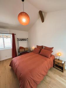a bedroom with a large bed with a orange bedspread at Bulles en Beaujolais in Fleurie