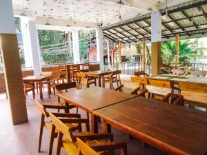 restauracja z drewnianymi stołami, krzesłami i oknami w obiekcie Eyeful Ella w mieście Ella