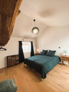 ein Schlafzimmer mit einem großen grünen Bett in einem Zimmer in der Unterkunft Bulles en Beaujolais in Fleurie