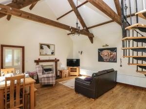 a living room with a staircase and a table and chairs at The Old Dairy in New Moat