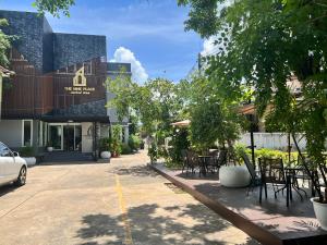 The Nine Place แจ้งสนิท في Ban Nong Bua: شارع فيه كراسي وطاولات امام مبنى