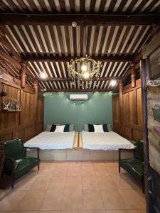 a bedroom with a bed and two green chairs at 緩緩歸 Slow living in Anping