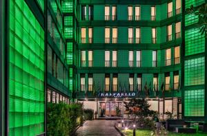 a green building with a sign on the side of it at Hotel Raffaello in Milan