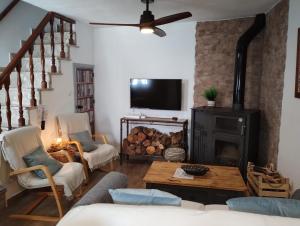 a living room with a fireplace and a tv at Casa Perejil, un balcón al Genal in Genalguacil