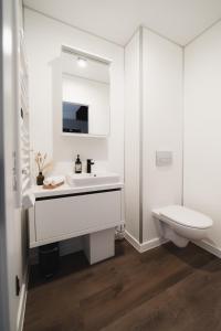 a white bathroom with a sink and a toilet at Neue stylische HÜSLE by UNIQUE PLACES in Bludenz