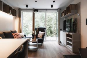 a living room with a couch and a tv at HŪSLE by UNIQUE PLACES - Stylische Tiny Houses in Vorarlberg in Bludenz