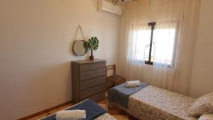 a bedroom with two beds and a mirror and a window at Villa Gení La Victoria by Ruralidays in La Victoria +34 photos