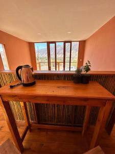 un tavolo in legno con un bollitore per il tè sopra di AMA WARA a Maimará