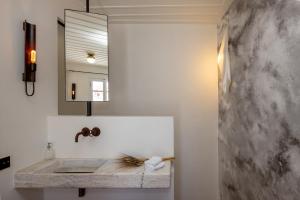 een badkamer met een marmeren wastafel en een spiegel bij Elayio Old Town in Tinos Town