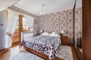 - une chambre avec un lit doté d'une couette violette et blanche dans l'établissement Apartamenty u Kukuca, à Szczawnica