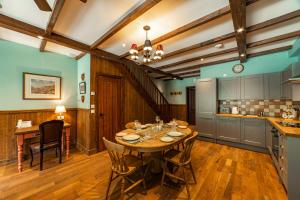 a dining room with a table and a kitchen at Black Sheep Hotels Cabins in Spean Bridge