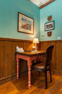 a desk with a telephone and a lamp on it at Black Sheep Hotels Cabins in Spean Bridge