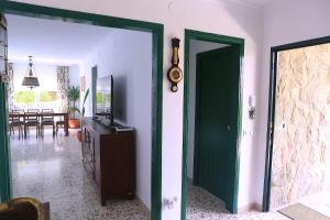 a room with a green door and a dining room at Newly furnished cozy house next to the beach in Calafell