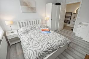 a bedroom with a bed with a zebra print sheets at Modern Watford Urban Luxury Oasis in Leavesden Green