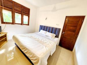 1 dormitorio con 1 cama grande y puerta de madera en Luxury Haven: Spacious Two Bedroom Villa with Parking, en Piliyandala