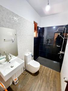 y baño con aseo, lavabo y ducha. en Luxury Haven: Spacious Two Bedroom Villa with Parking, en Piliyandala